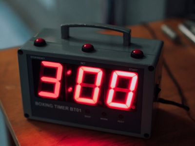 Stopwatch and water bottle on a bench in gym